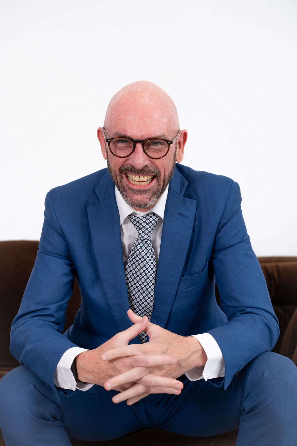 Adam Leishman smiling in a blue suit